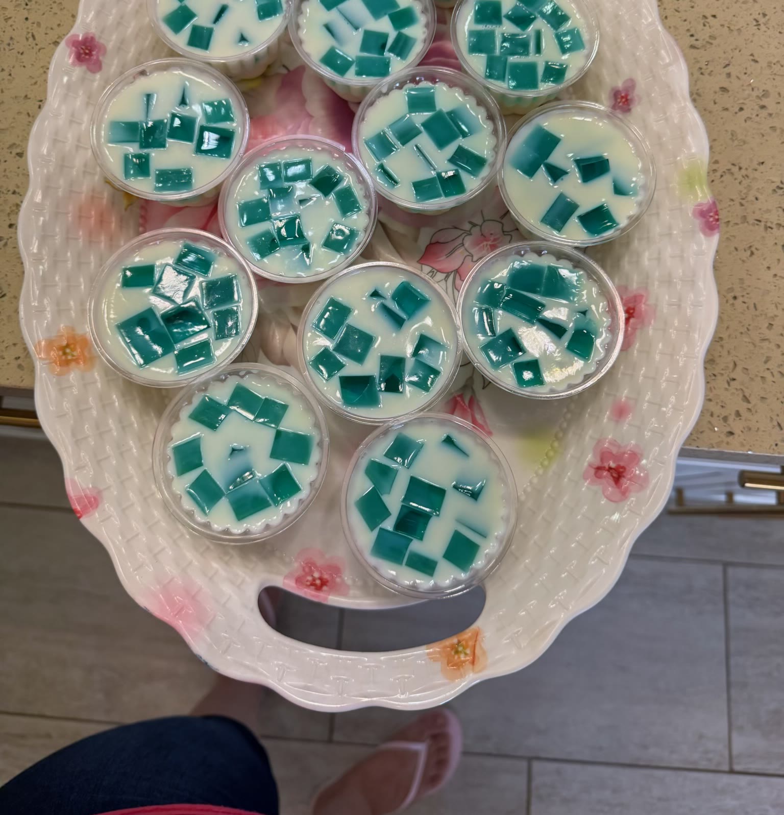 Tray of mosaic gelatina cups with teal jello cubes in cream gelatin