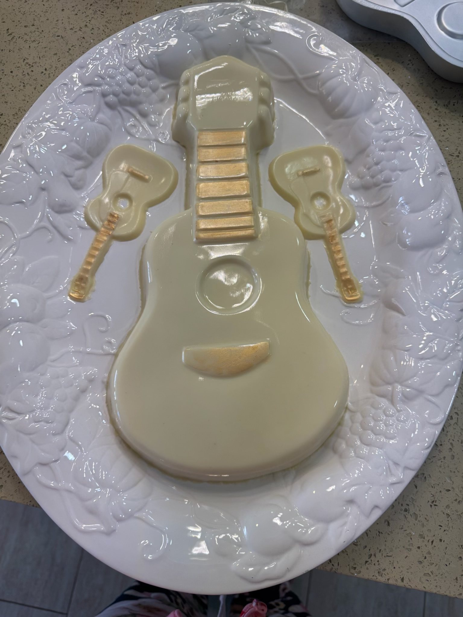White chocolate guitar with two small chocolate guitars on a plate