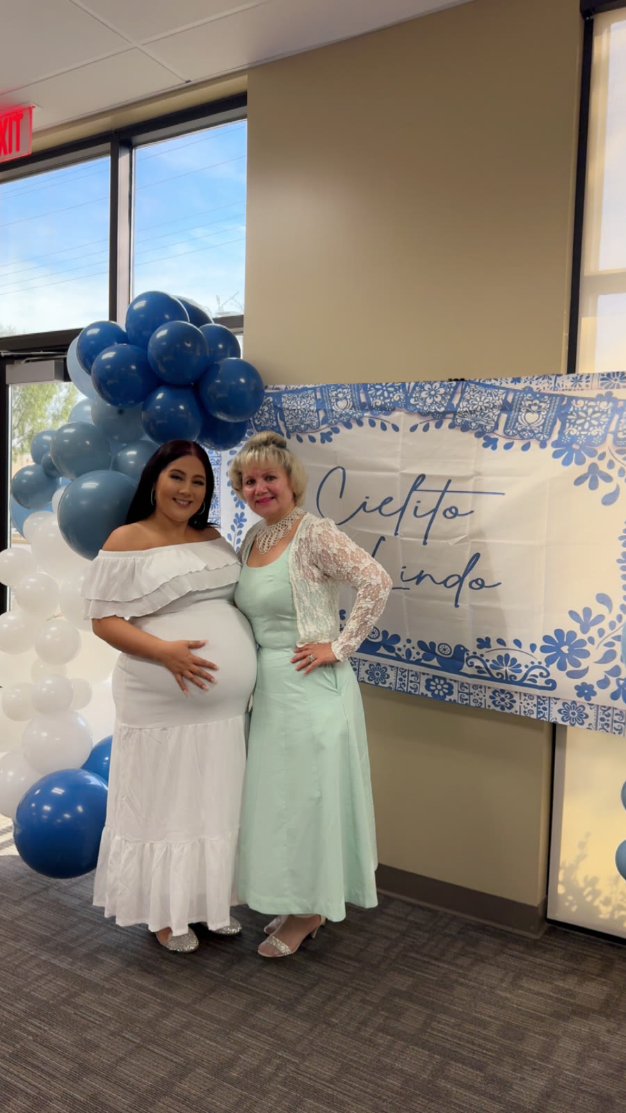 Two guests smiling at a baby shower balloon backdrop